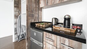 Een moderne keuken met houten kastjes, een zwart aanrecht en roestvrijstalen apparatuur.
