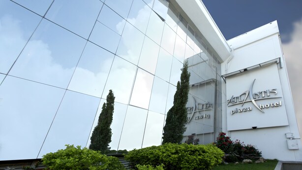 Un edificio moderno con fachada de vidrio reflectante y un cartel que indica el "Antis Plaza Hotel".