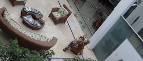 A spacious outdoor area with a modern lounge featuring wicker furniture and a decorative star emblem.