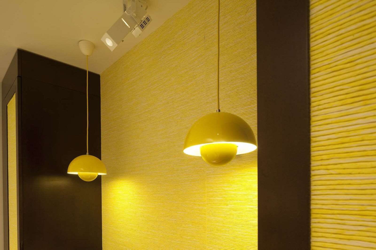 A modern interior with two pendant lights and a textured wall.