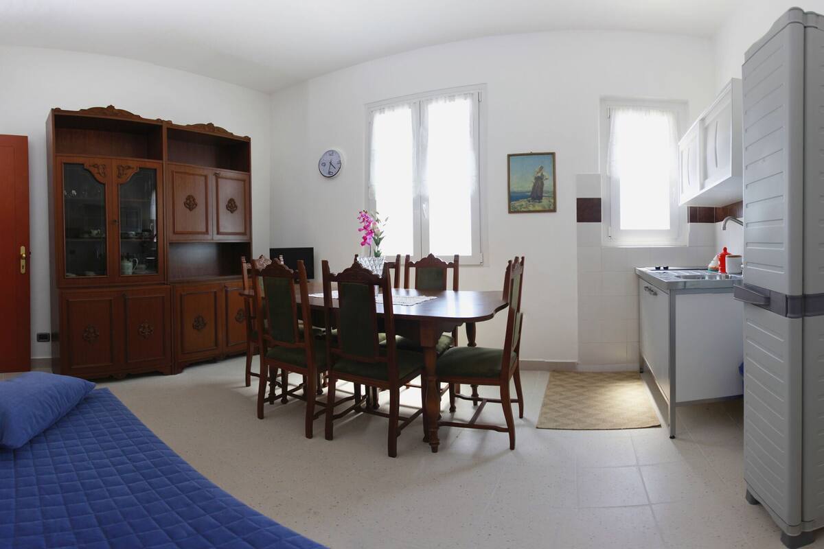 Ein kompakter Wohnbereich mit Essplatz, Küchenzeile, Bett und Kleiderschrank.