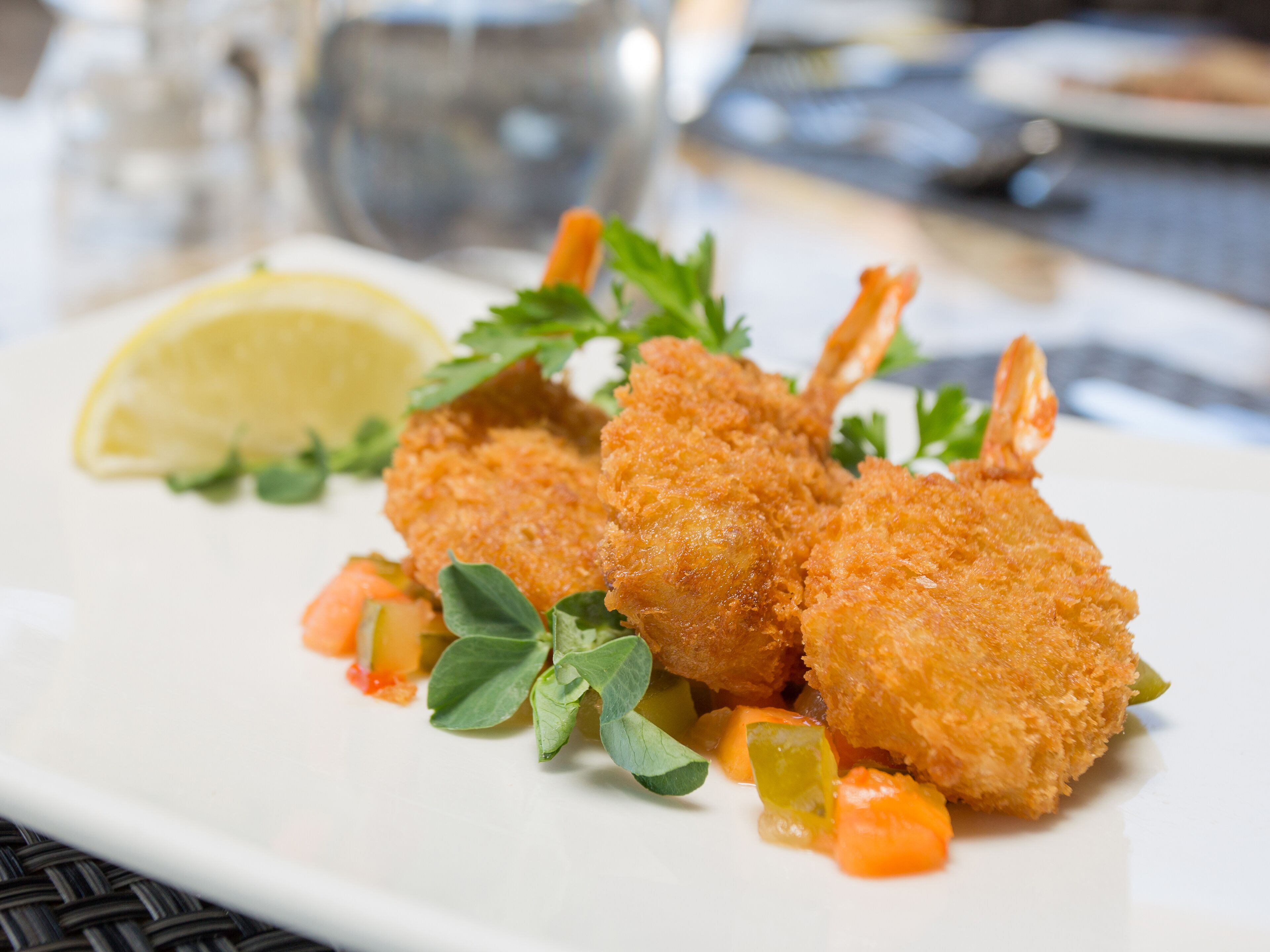 Ein Teller mit paniertem und frittiertem Essen, garniert mit Petersilie und Zitrone.