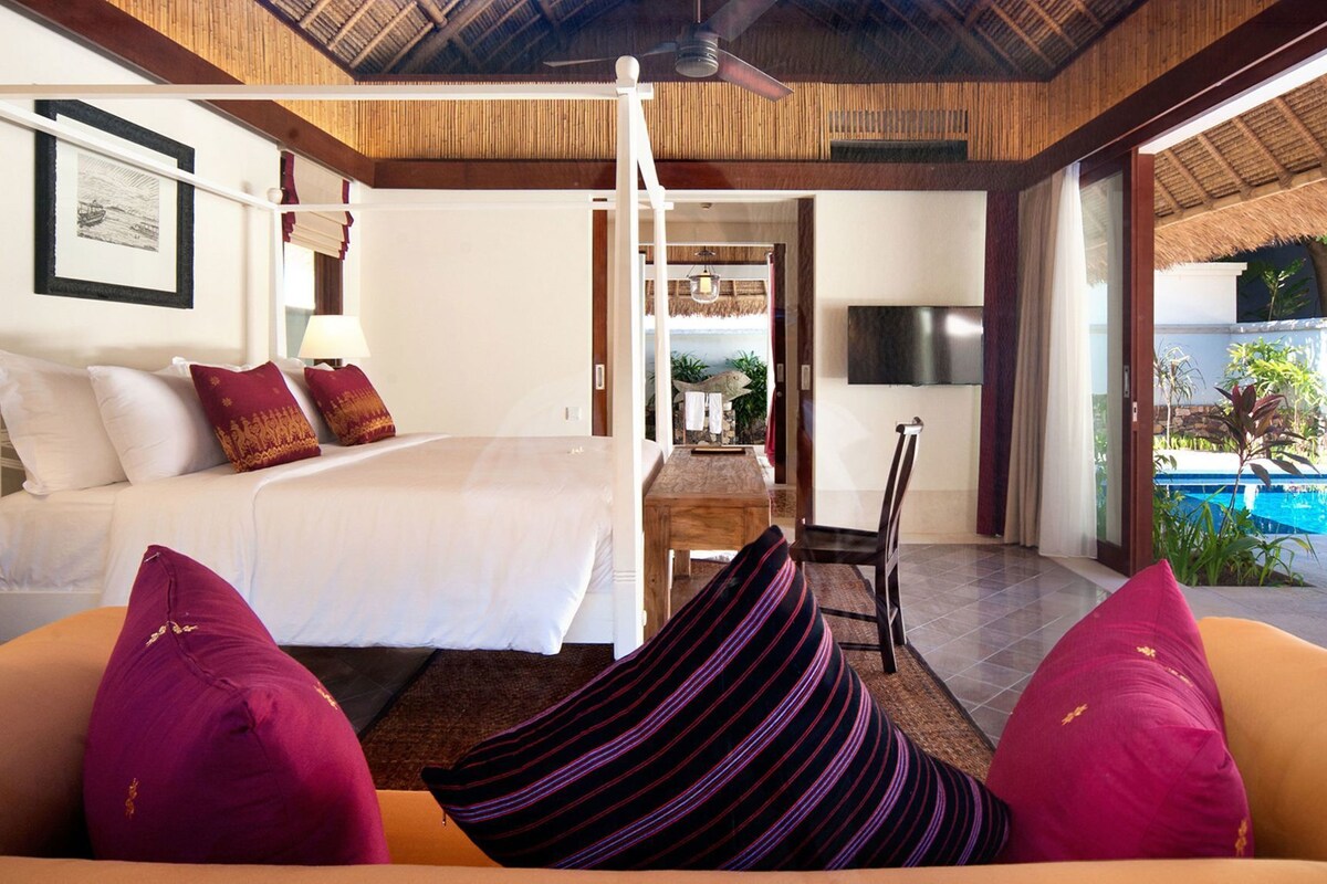 A bedroom with a bed, bedside table, and a TV.