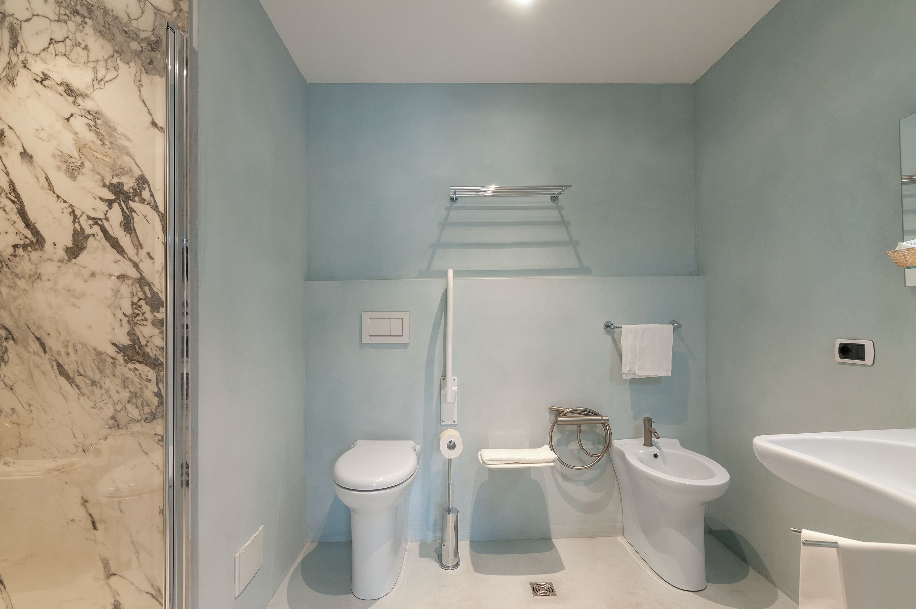 Un baño con inodoro, bidé y lavabo.