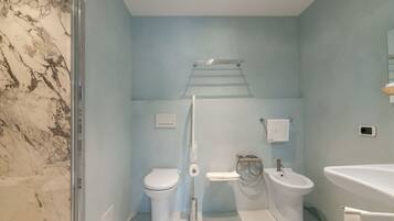 Un baño con inodoro, bidé y lavabo.