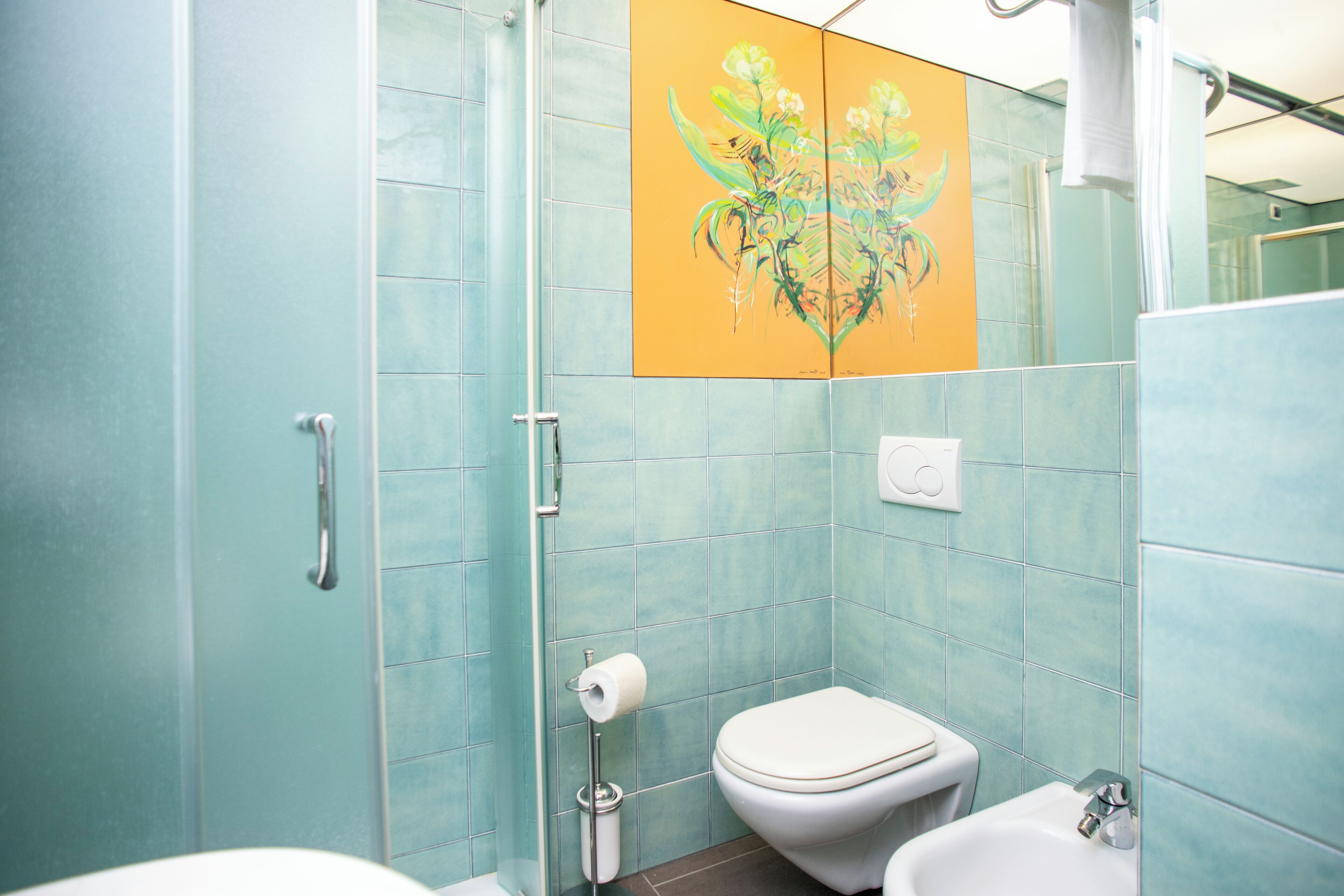 A bathroom with a toilet, bidet, and a shower area.