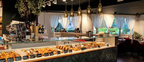 A bakery counter with various pastries and a coffee machine.
