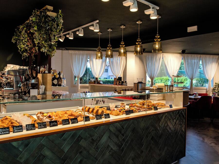 A bakery counter with various pastries and a coffee machine.