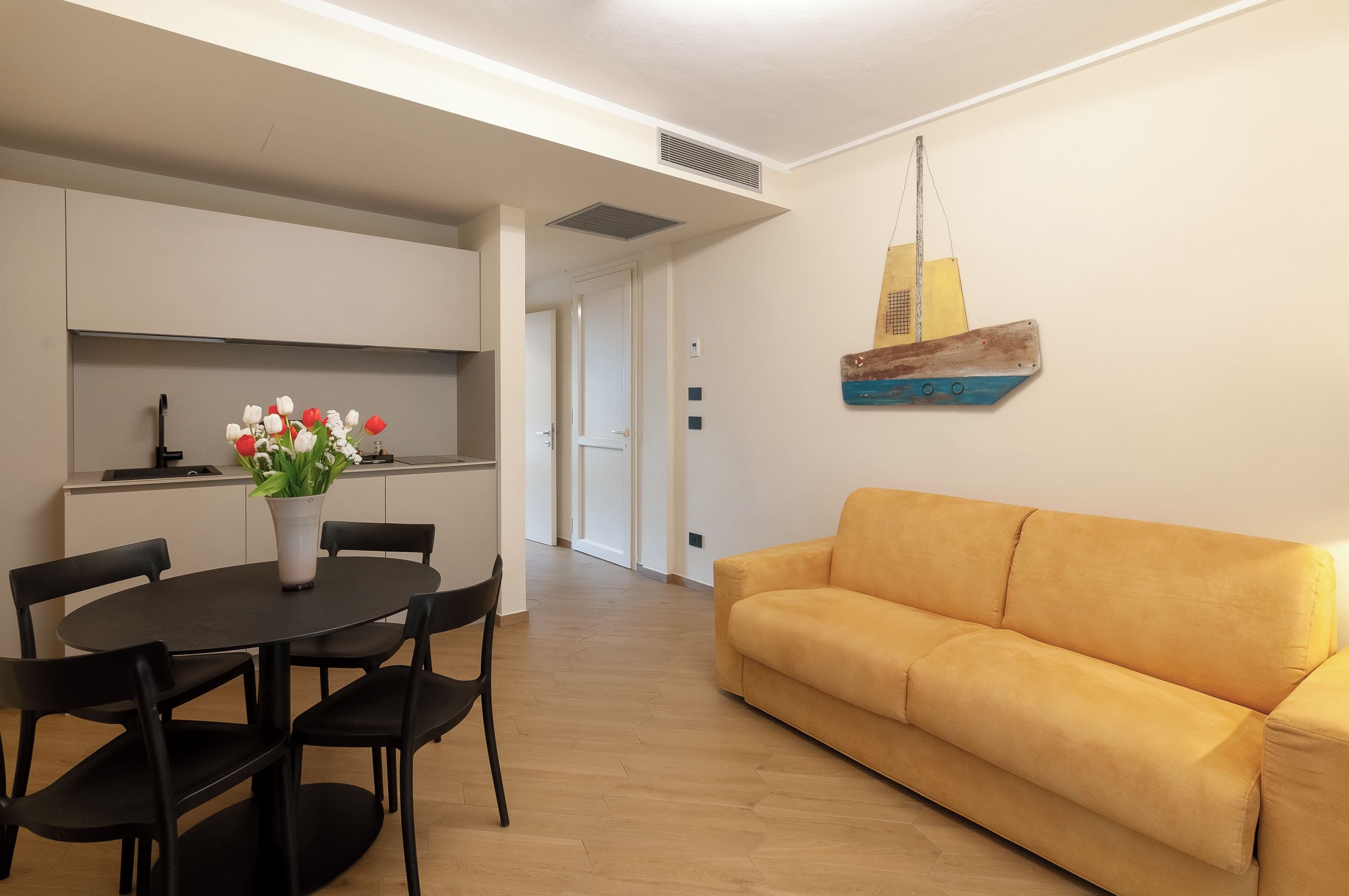 Una sala moderna con un sofá y una mesa de comedor con sillas.