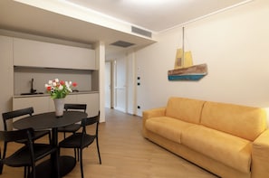 Una sala moderna con un sofá y una mesa de comedor con sillas.