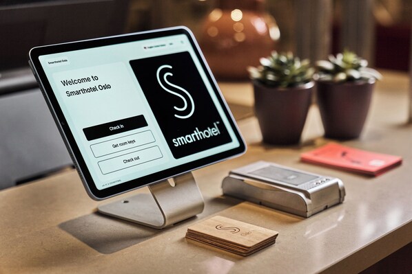 A digital check-in kiosk at Smarthotel Oslo with a screen displaying a welcome message and options to check in, get room keys, or check out. - Smarthotel Oslo (Oslo)