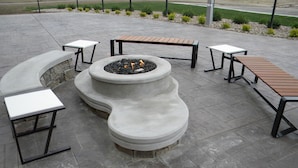 A fire pit surrounded by benches and tables on a paved patio. - MainStay Suites Rapid City (Rapid City)