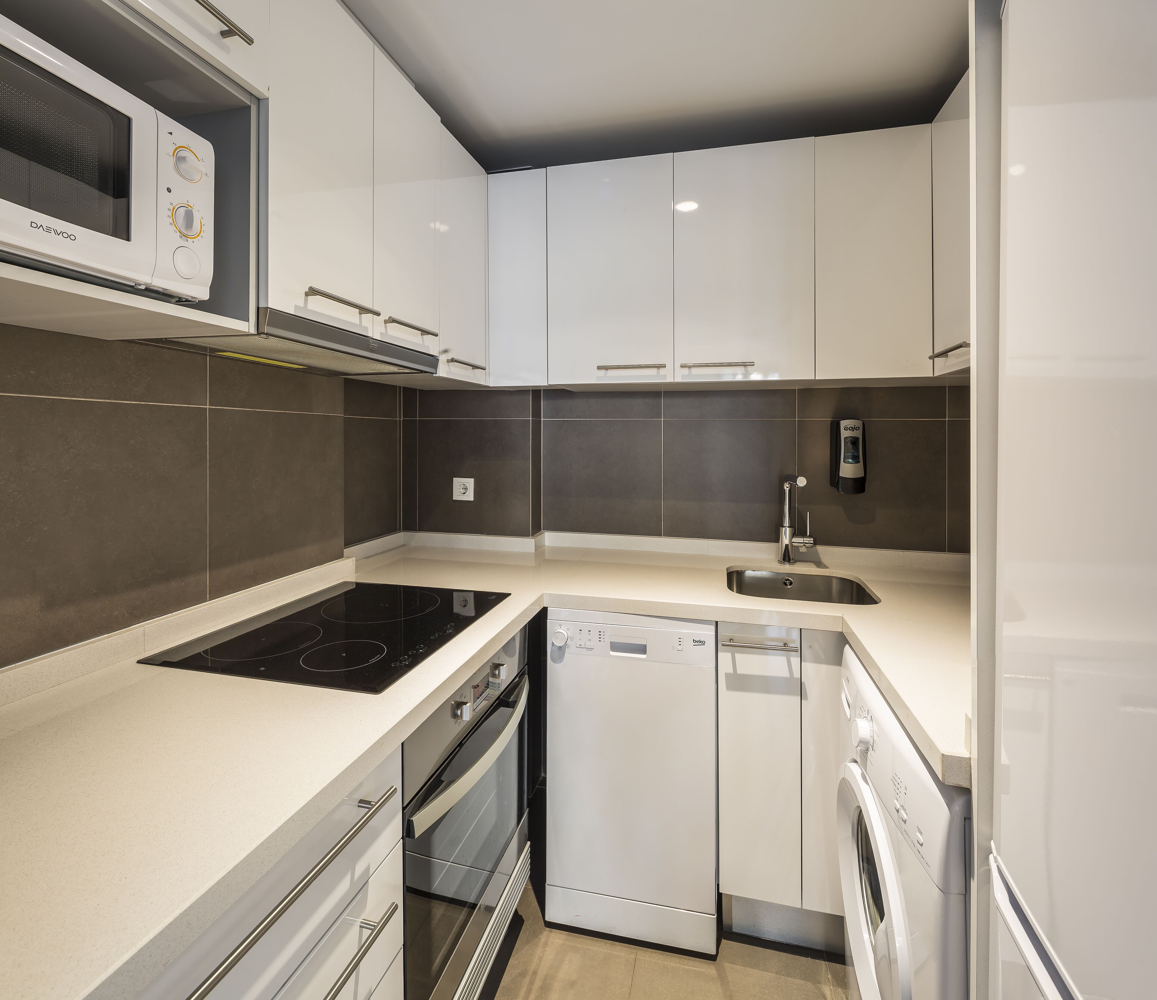A modern kitchen with a built-in stove, oven, dishwasher, and a microwave.