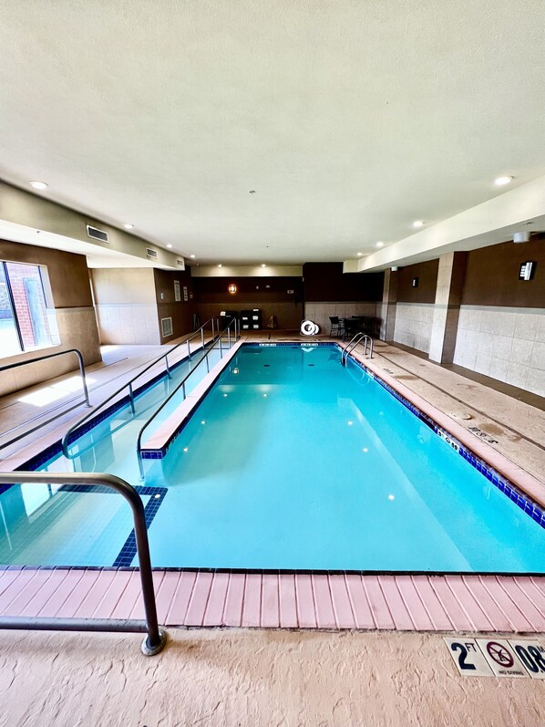 A swimming pool with a tiled edge, a metal handrail, and a sign indicating a 2ft depth limit. - Holiday Inn Express Hotel & Suites Alva by IHG (Alva)