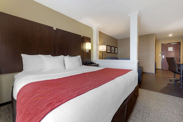 A hotel room with a large bed, a desk, and a chair. - Comfort Suites and Conference Center (Worthington)