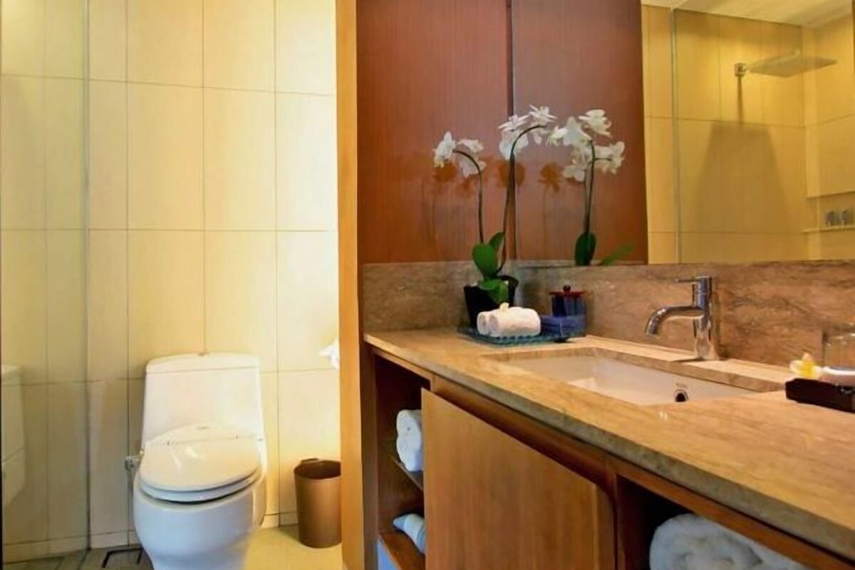 A modern bathroom with a toilet, sink, and a mirror.