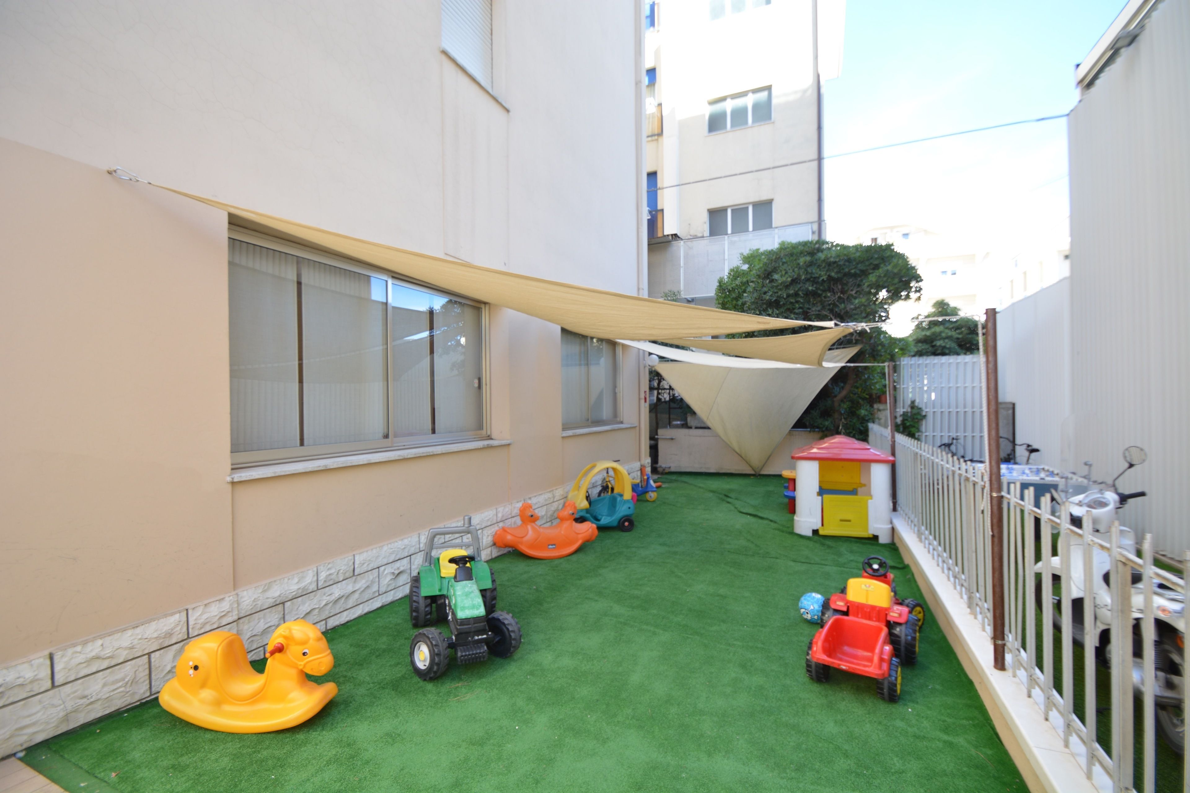 A children's play area with various toys and a small playhouse.