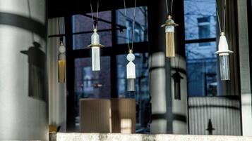 Un intérieur moderne avec des luminaires suspendus, un comptoir en marbre et une vue dégagée grâce à de grandes fenêtres.