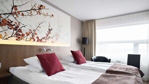 A hotel room with two beds, a large window, a lamp, and a wall art piece. - Best Western Hotell Ljungby (Ljungby)
