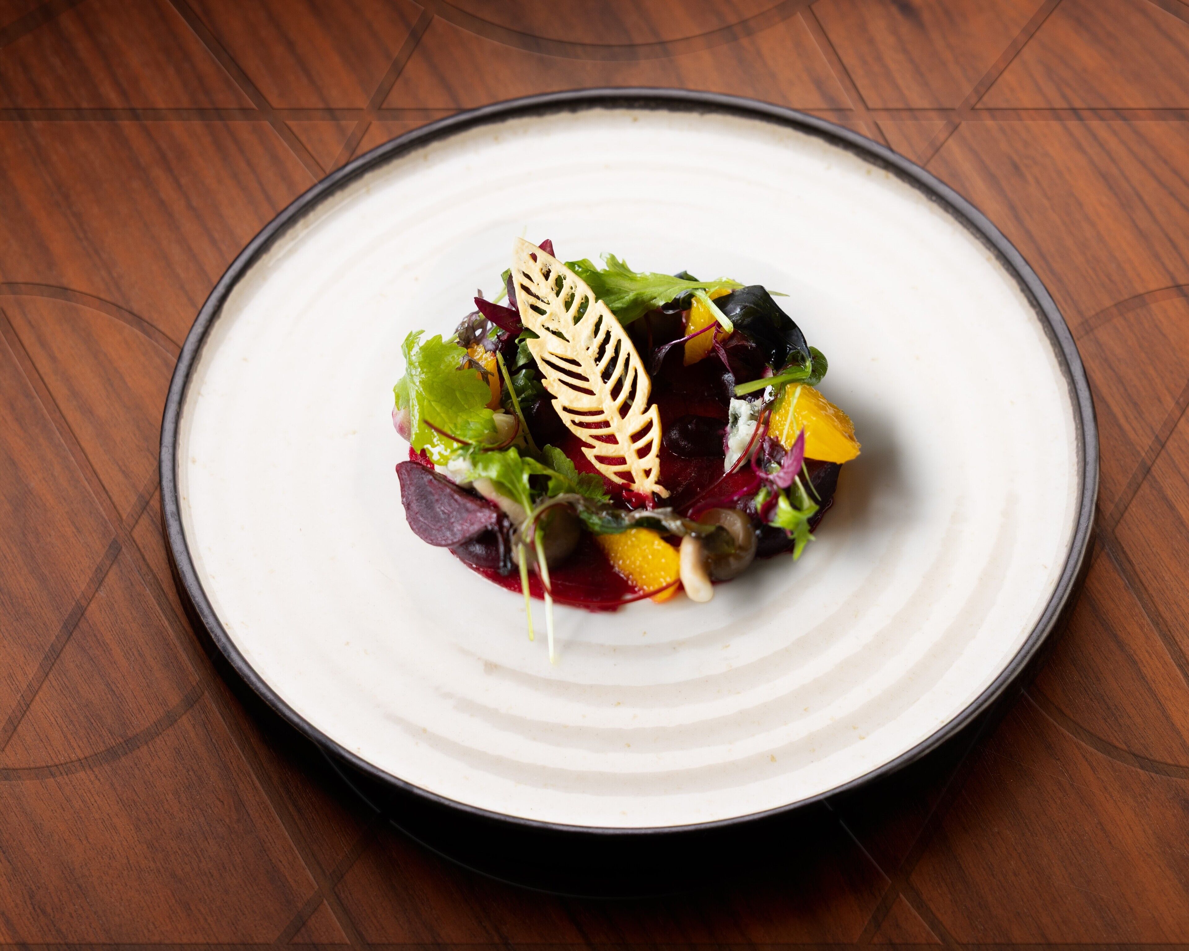 Un plato blanco con una ensalada colorida sobre una mesa de madera.