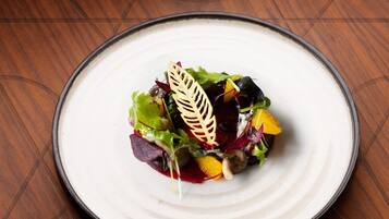 Un plato blanco con una ensalada colorida sobre una mesa de madera.