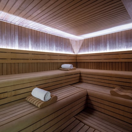 A sauna with wooden benches and a clock on the wall.