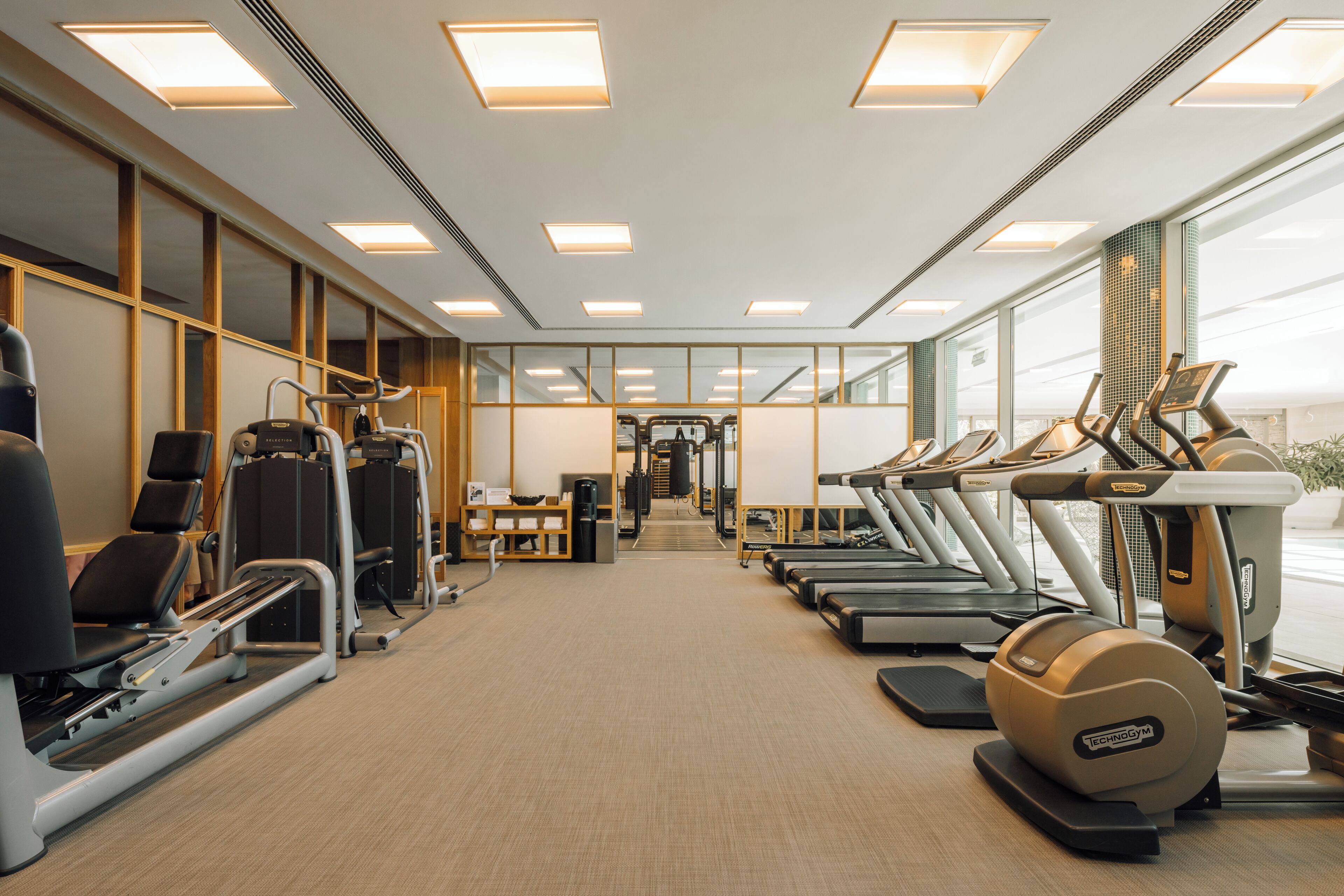 A gym with treadmills, elliptical machines, and weight equipment.
