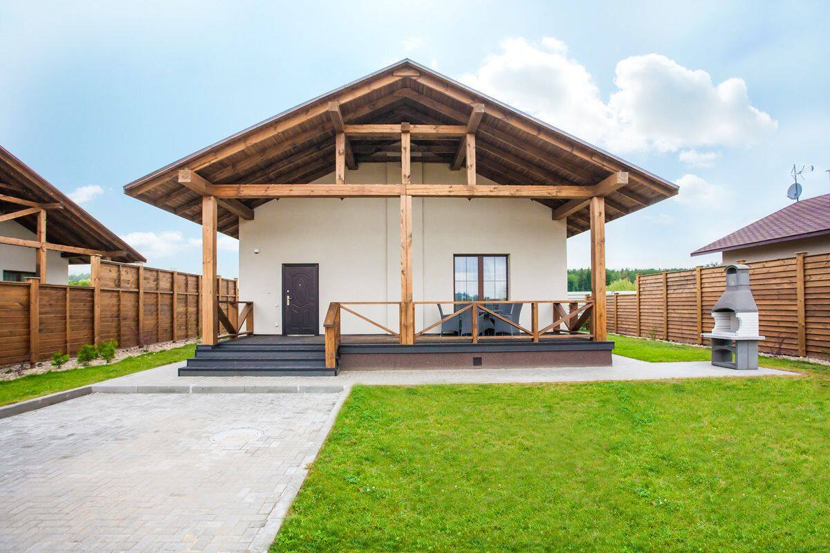 A modern building with a wooden facade, a covered entrance, and a paved driveway.