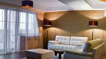 Ein modernes Wohnzimmer mit einem weißen Ledersofa, einem passenden Ottomanen und zwei Stehlampen.