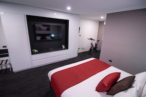 Luxury King + In Room Exercise Equipment | Living area | Flat-screen TV - Golden West Motor Inn (Dubbo)