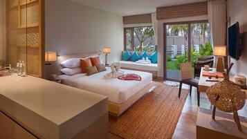 Quarto de hotel com uma cama grande, área de estar com vista e mesa de jantar.