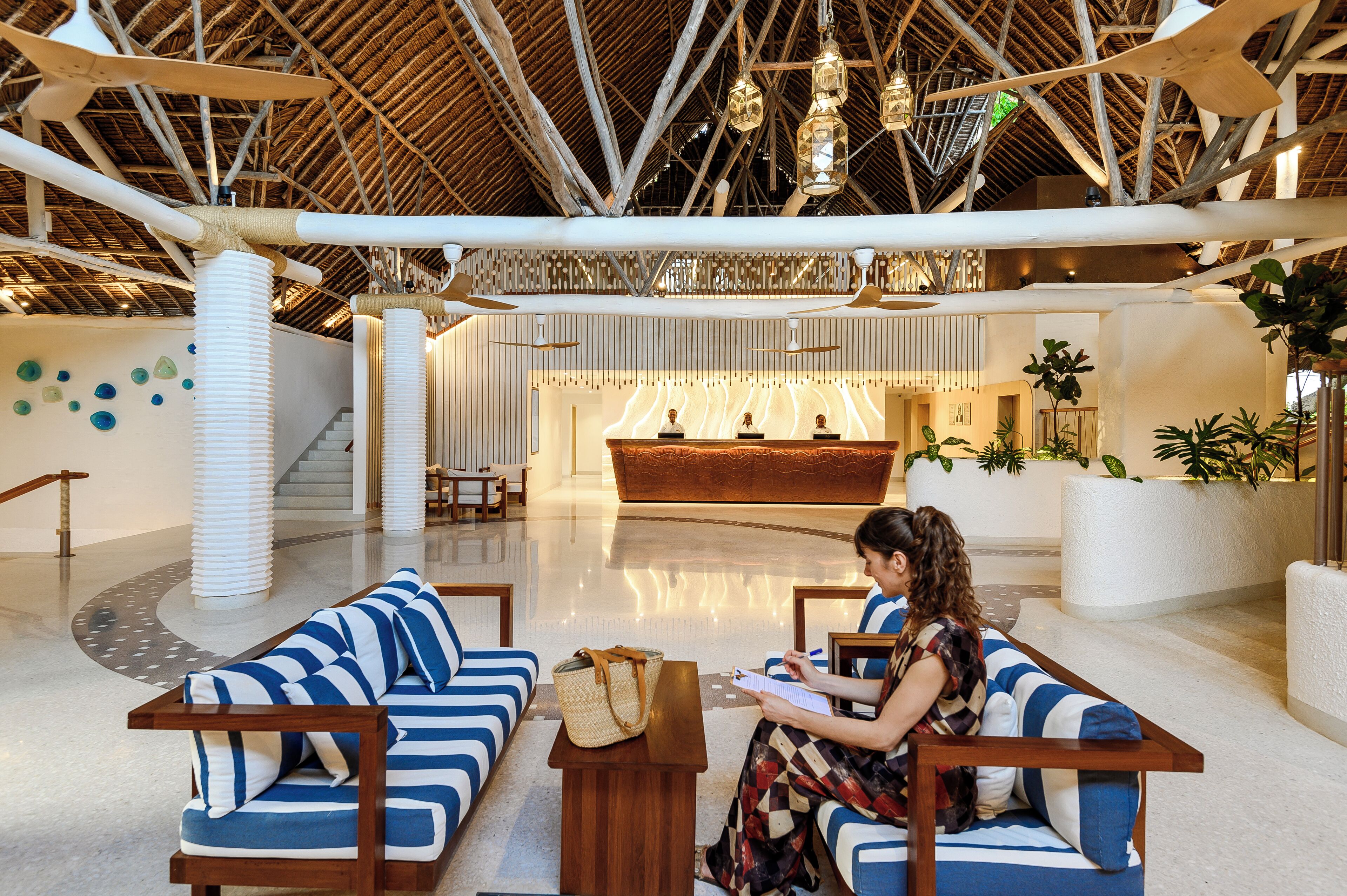 A spacious lobby with a high ceiling, a reception desk, and seating areas.