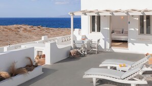 A white building with a balcony overlooking the sea. - Vrachia Studios & Apartments (Santorini)