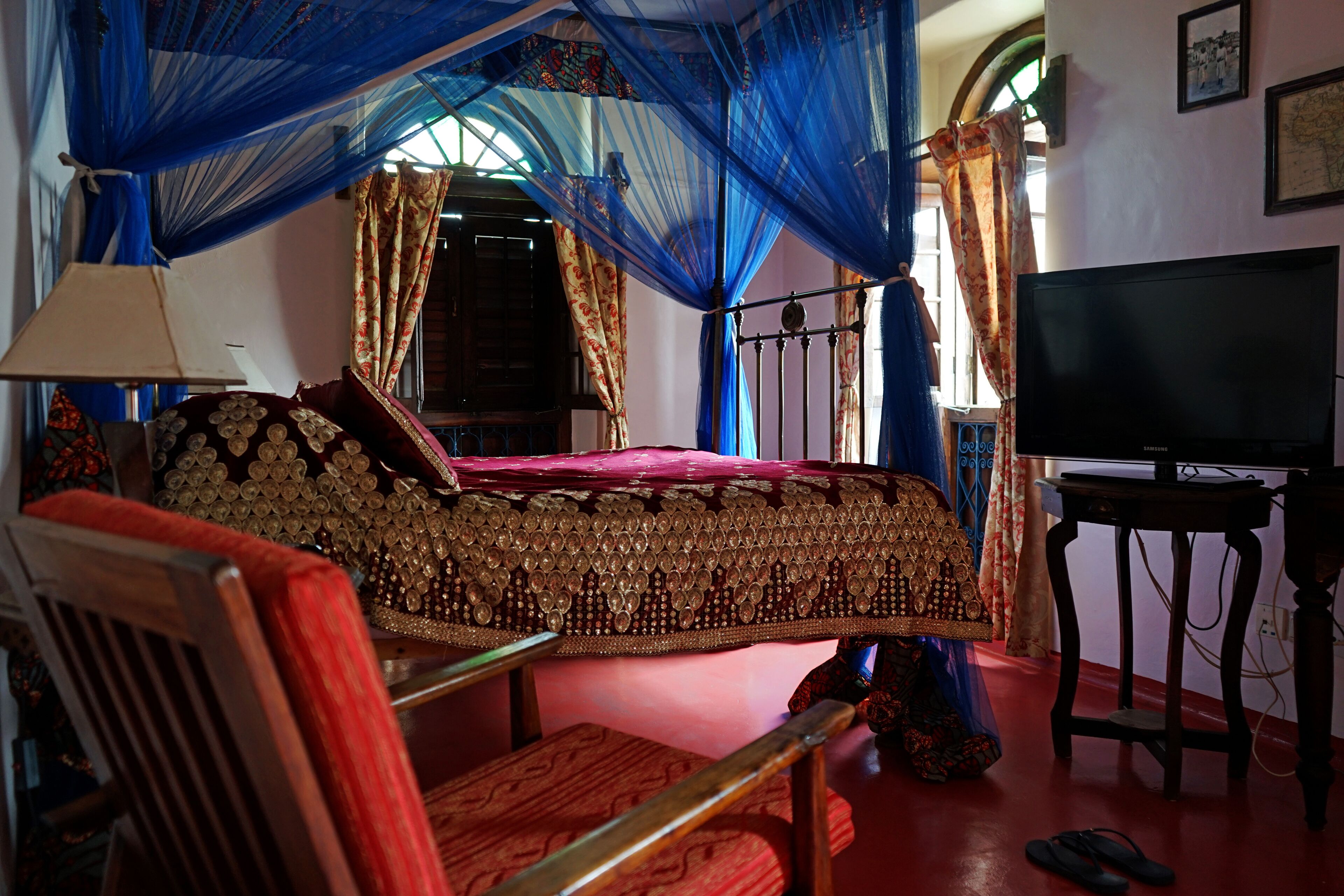 A room with a bed, a TV, and a chair.