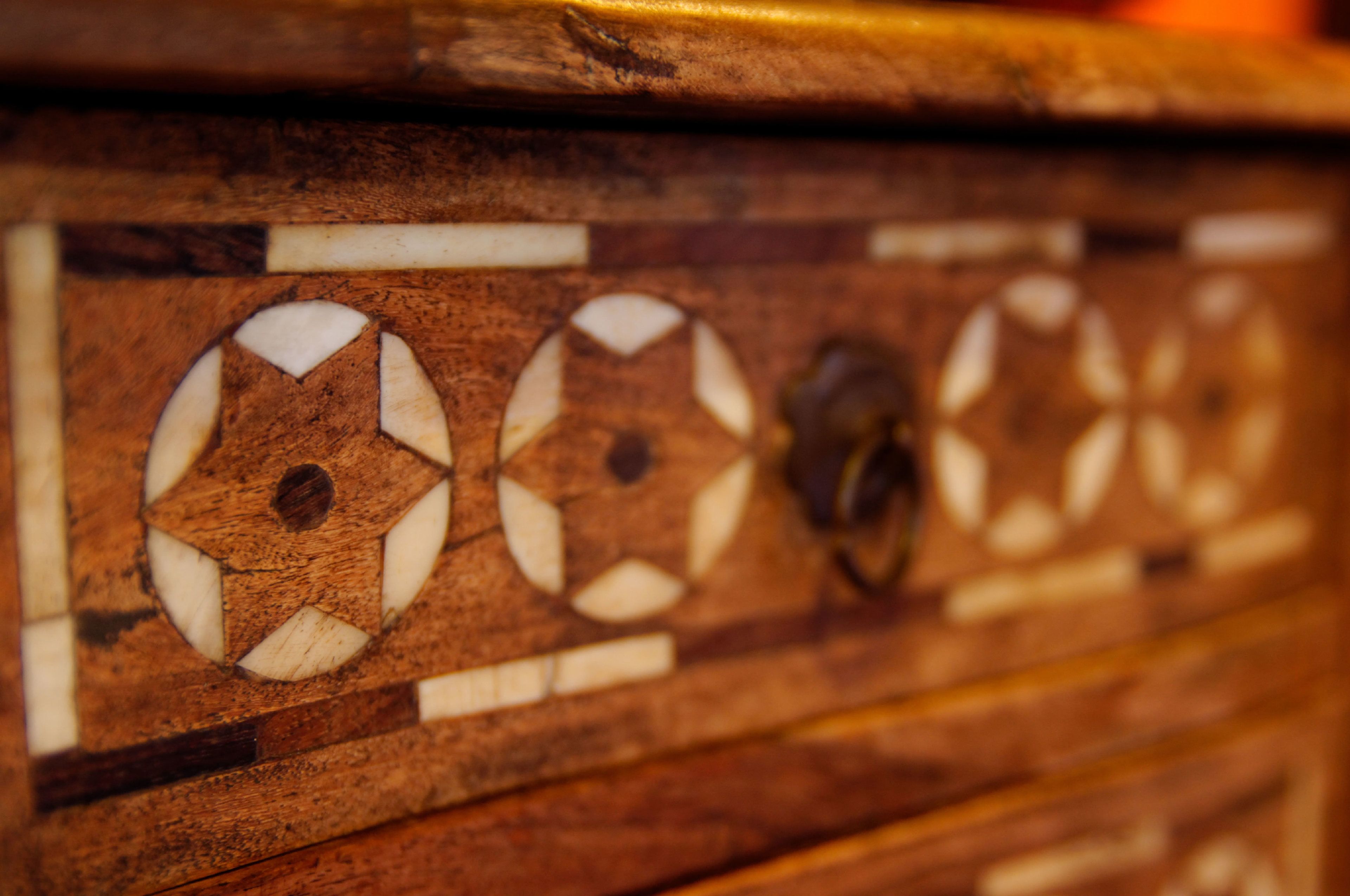 Primer plano de una superficie de madera con diseños circulares y una cerradura.
