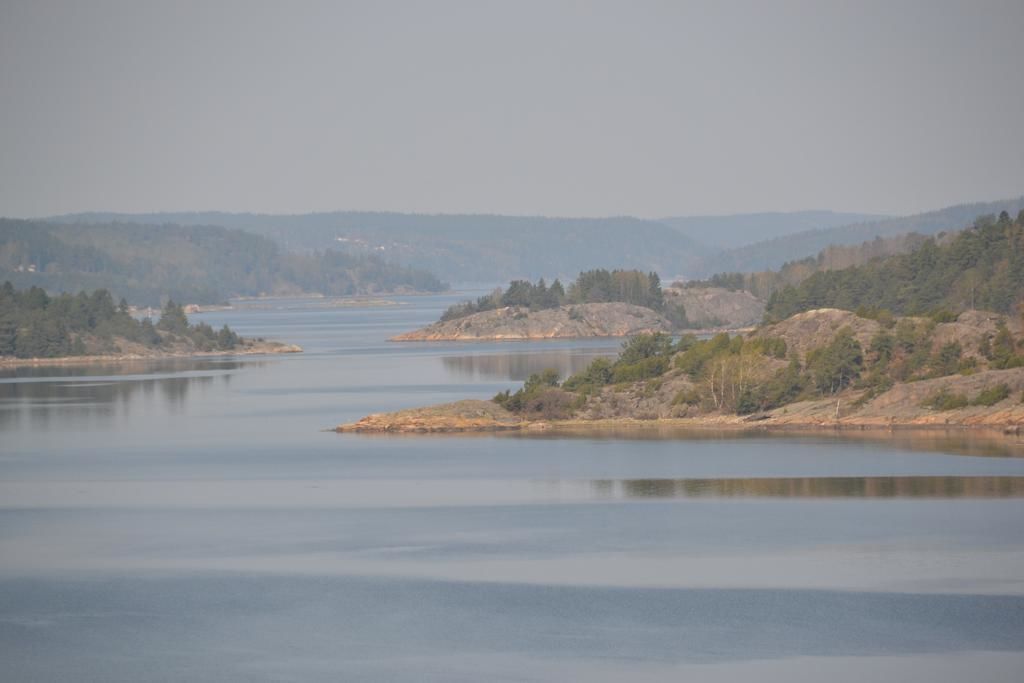 En stilla flod med steniga stränder och träd längs dess sidor.