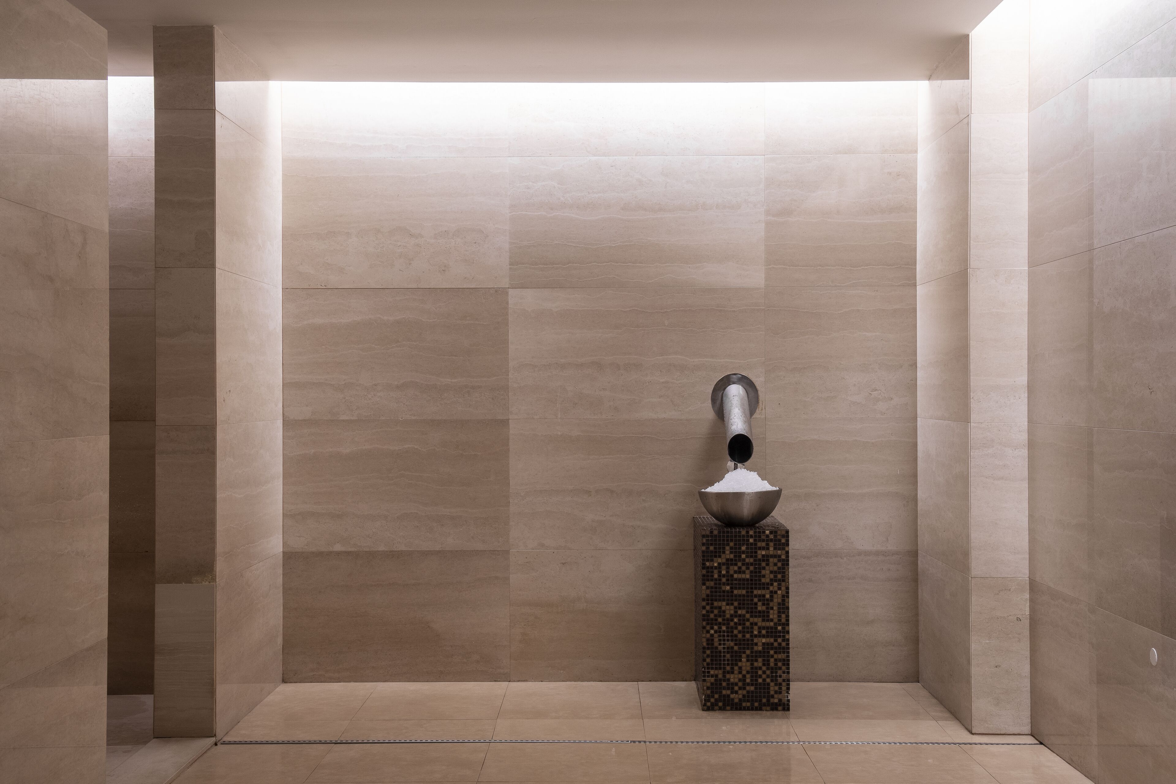 A modern bathroom with a minimalist design, featuring a large mirror, a toilet, and a sink.