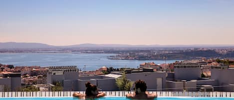 Una piscina techada, una piscina al aire libre de temporada, sombrillas