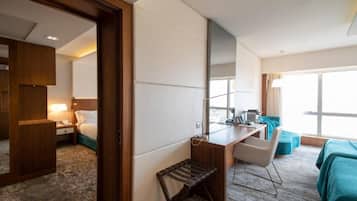 Hotellihuone, jossa on sänky, työpöytä, tuoli ja näkymä ulos.