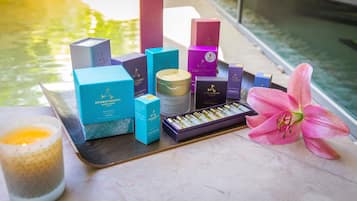 A tray with various skincare products and a candle, placed near a water body.