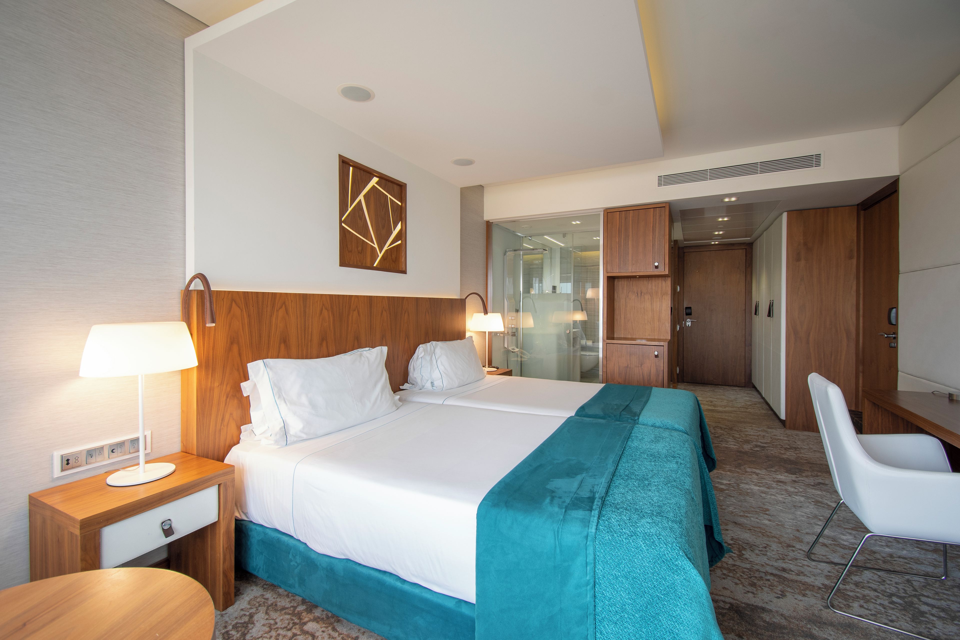 Une chambre d’hôtel comprenant un lit, des tables de chevet, un bureau et une chaise.