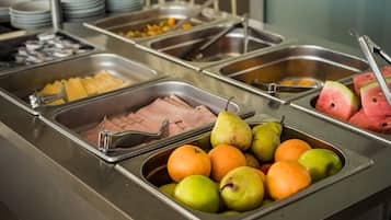 A buffet with various food options including fruits, vegetables, and meats.