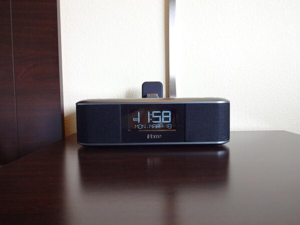 Um relógio digital mostrando 11:50 sobre uma mesa de madeira escura.