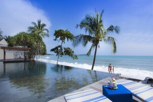 Una piscina al aire libre, sombrillas, tumbonas