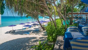 A beachside hotel with sun loungers, umbrellas, and a pool area. - Synergy Samui (Koh Samui)