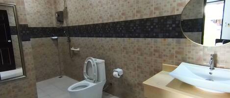 Un baño con inodoro, lavamanos y ducha.
