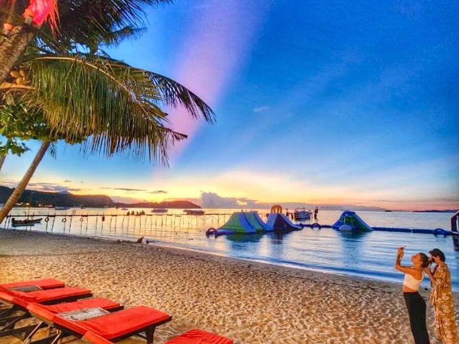 Na praia, areia branca, espreguiçadeiras, guarda-sóis