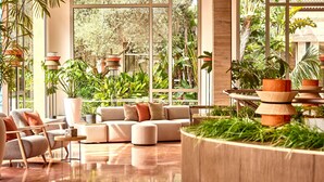 A modern living room with a sofa set, a coffee table, and a large window overlooking a lush garden. - Zafiro Ca'n Picafort (Santa Margalida)