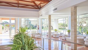 A spacious lobby with a high ceiling, large windows, and a central seating area with white sofas. - Zafiro Ca'n Picafort (Santa Margalida)