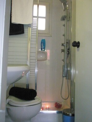 Une salle de bain comprenant des toilettes, un lavabo et une douche.